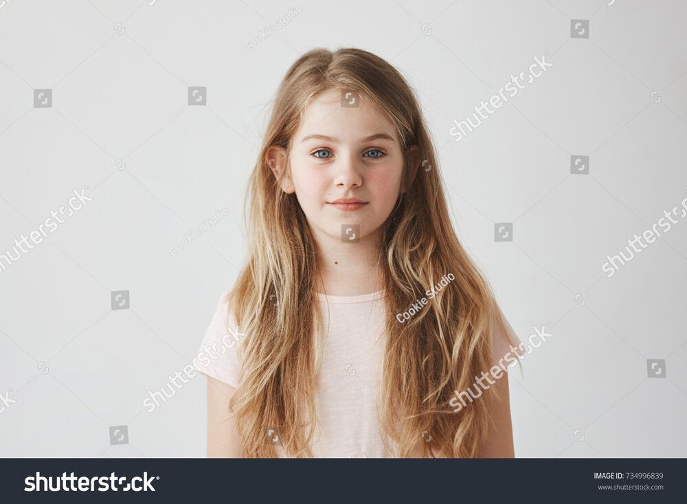 Stock photo close up portrait of good looking young girl with blond hair in pink dress looking
