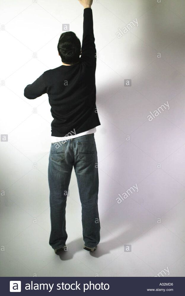 Full shot of man stretching on his tip toes to get something out of A02MD6