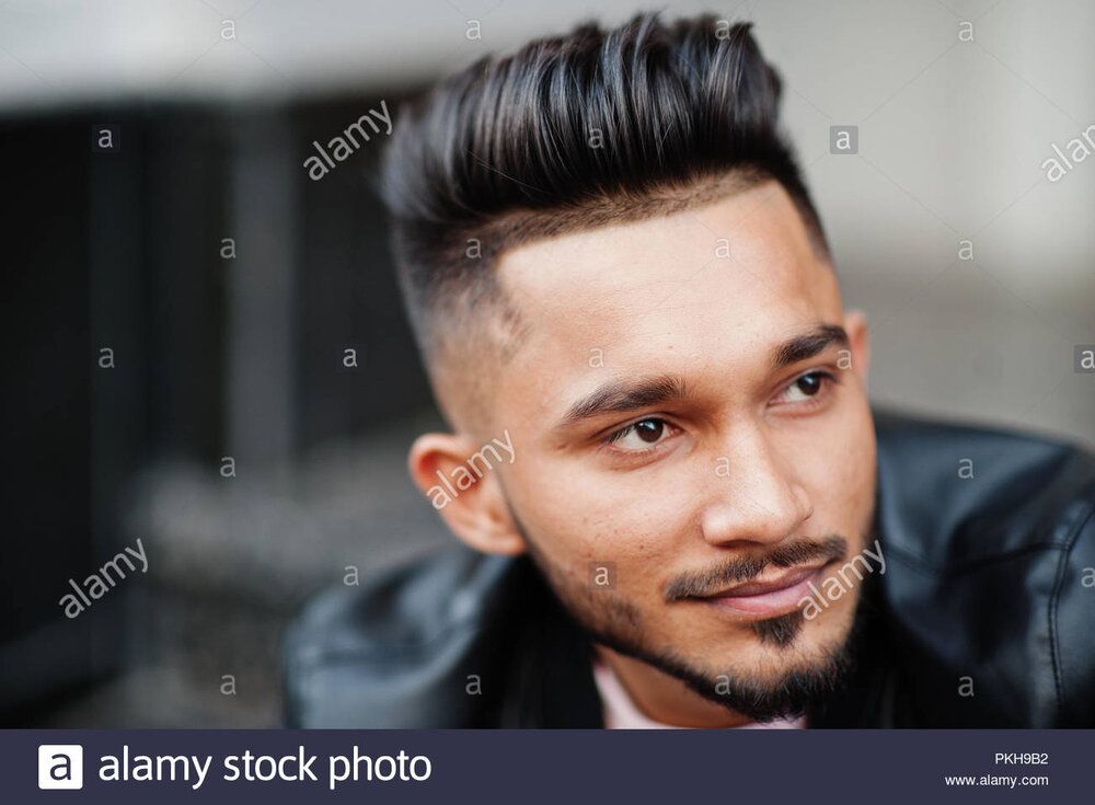 Stylish indian beard man at black leather jacket india model posed sitting at streets of city 