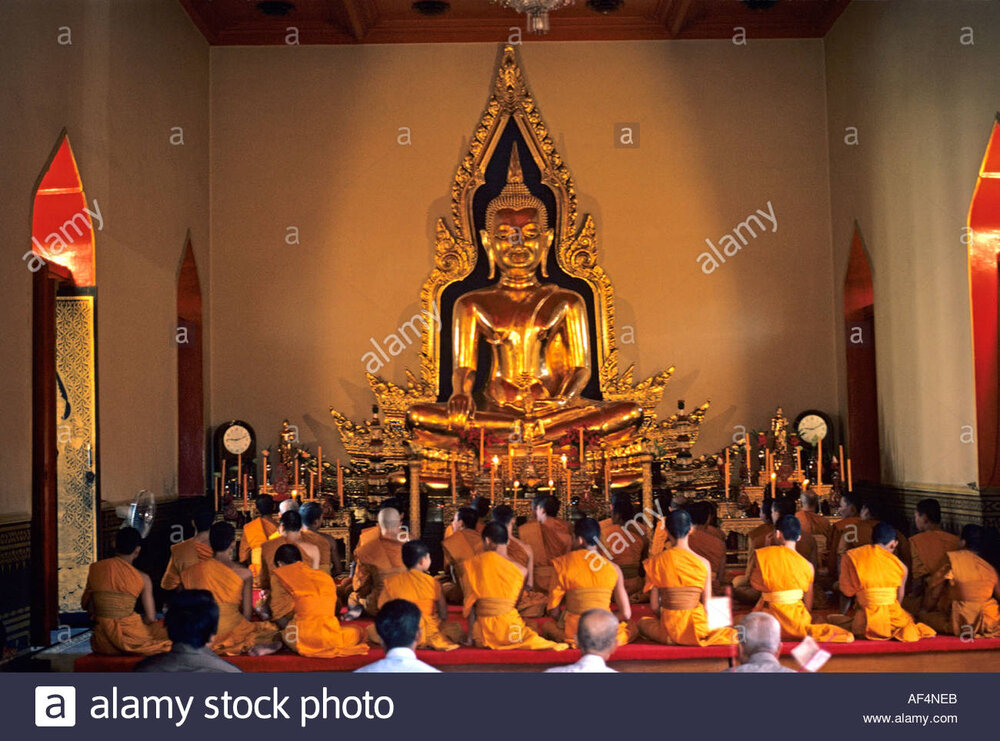 Buddhist temple interior with lines of the backs of monks at worship AF4NEB