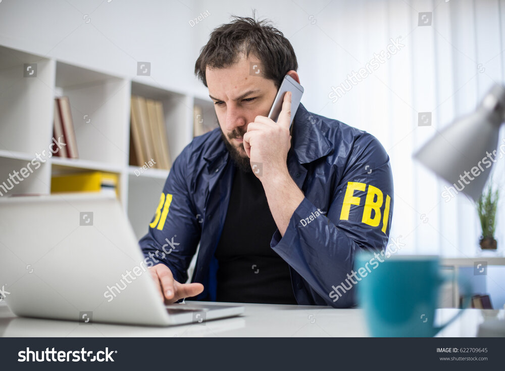 Stock photo fbi agent working in his office talks on mobile and looking at laptop 622709645