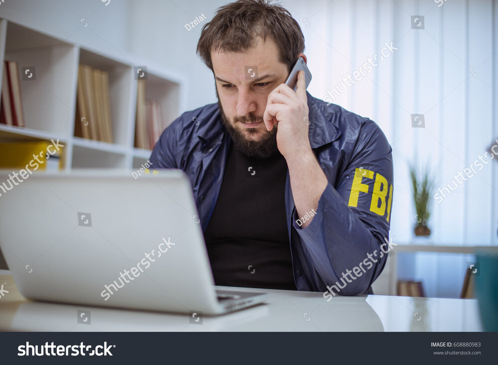 Stock photo fbi agent working in his office on laptop and talking on mobile phone 608880983