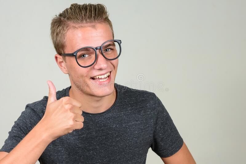 Studio shot young handsome nerd man blond hair wearing eyeglasses against white background hap