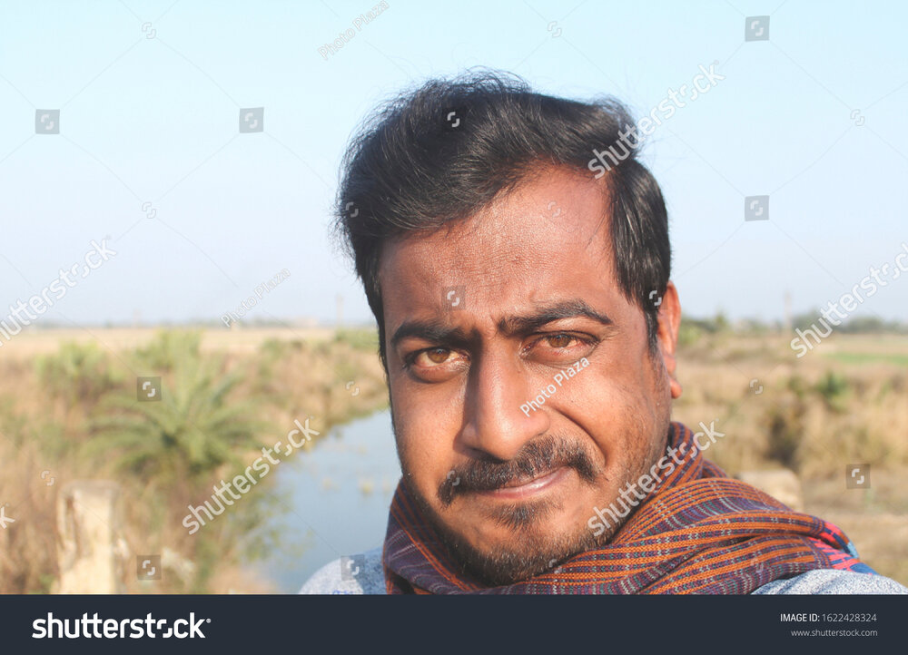 Stock photo an indian young handsome man showing his ugly and extremely funny facial expressio