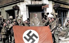 Soldiers of the 70th division of the American 7th Army hold up a Nazi flag  & a portrait of Hitler. | VE Day in colour: 73rd anniversary of end of  World War