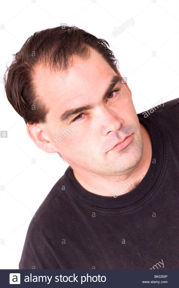 A serious looking man with receding hair line is looking directly BKD55P
