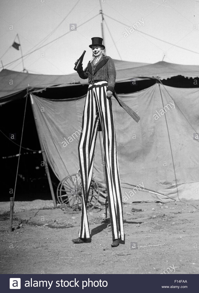 1930s circus performer smiling clown on stilts striped pants looking F14FAA