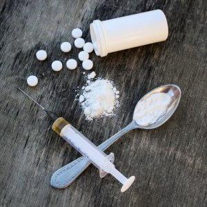 White pill syringe and heroin 94632920 copy 300x300