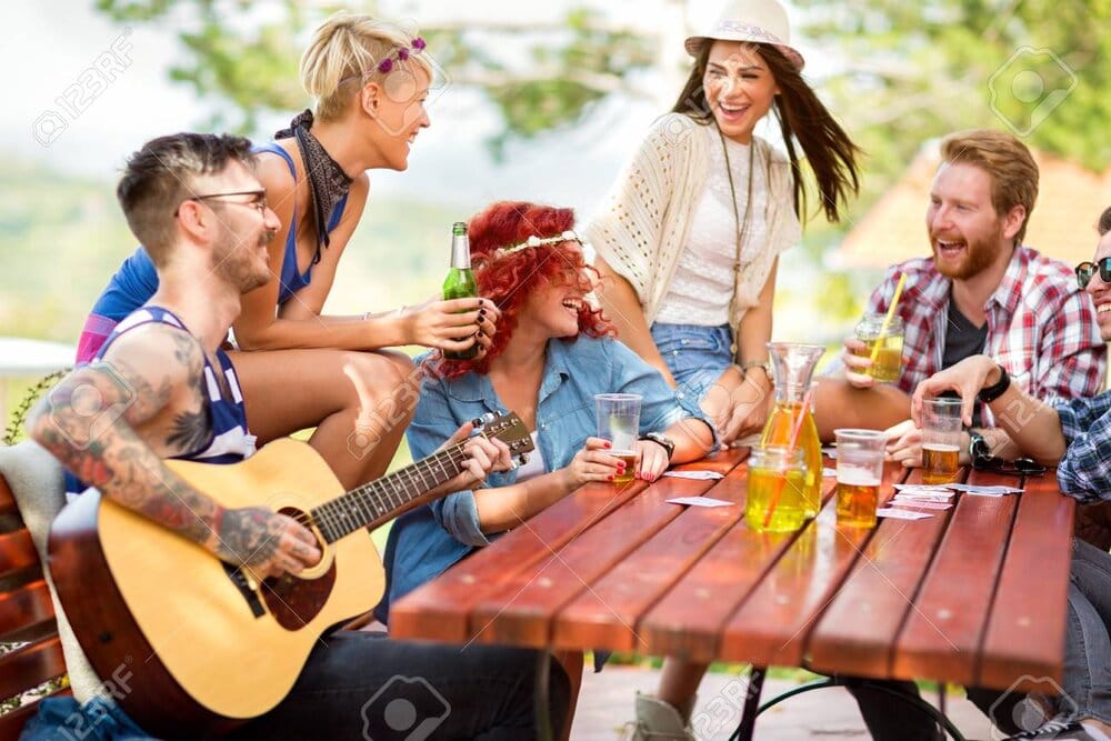 55667615 cheerful young friends enjoying together with music and beer in nature