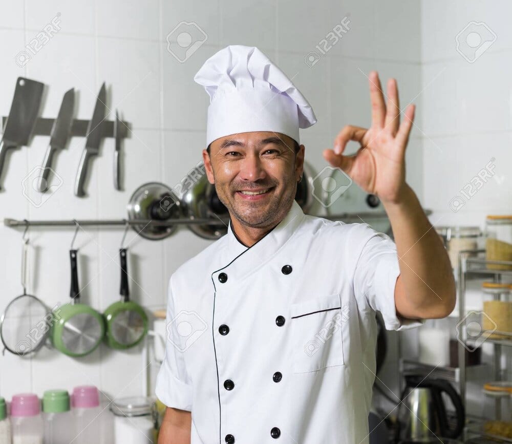 53343696 asian chef smiling and showing ok on the kitchen background focus on face hand blured 