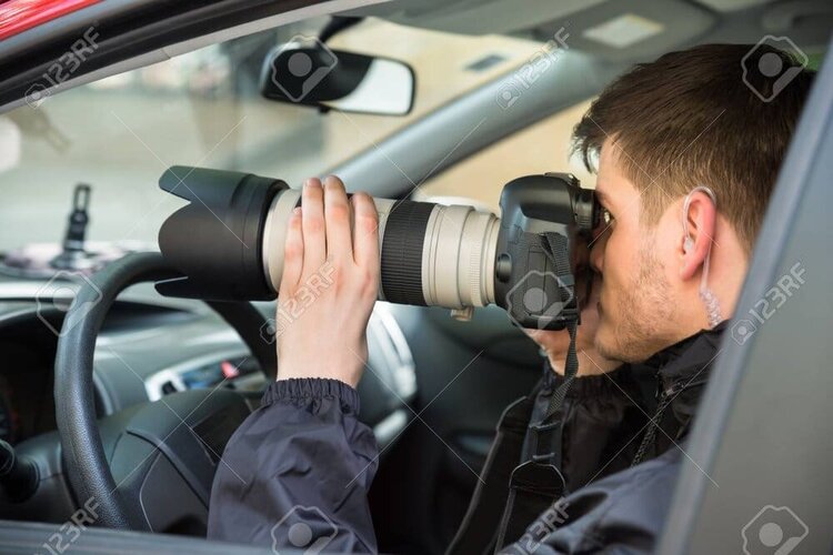 84565347 close up of a young man inside car photographing with slr camera