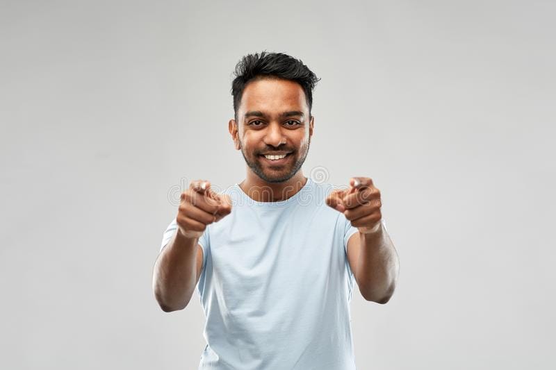 Smiling indian man pointing fingers you choice people concept young over grey background 13234