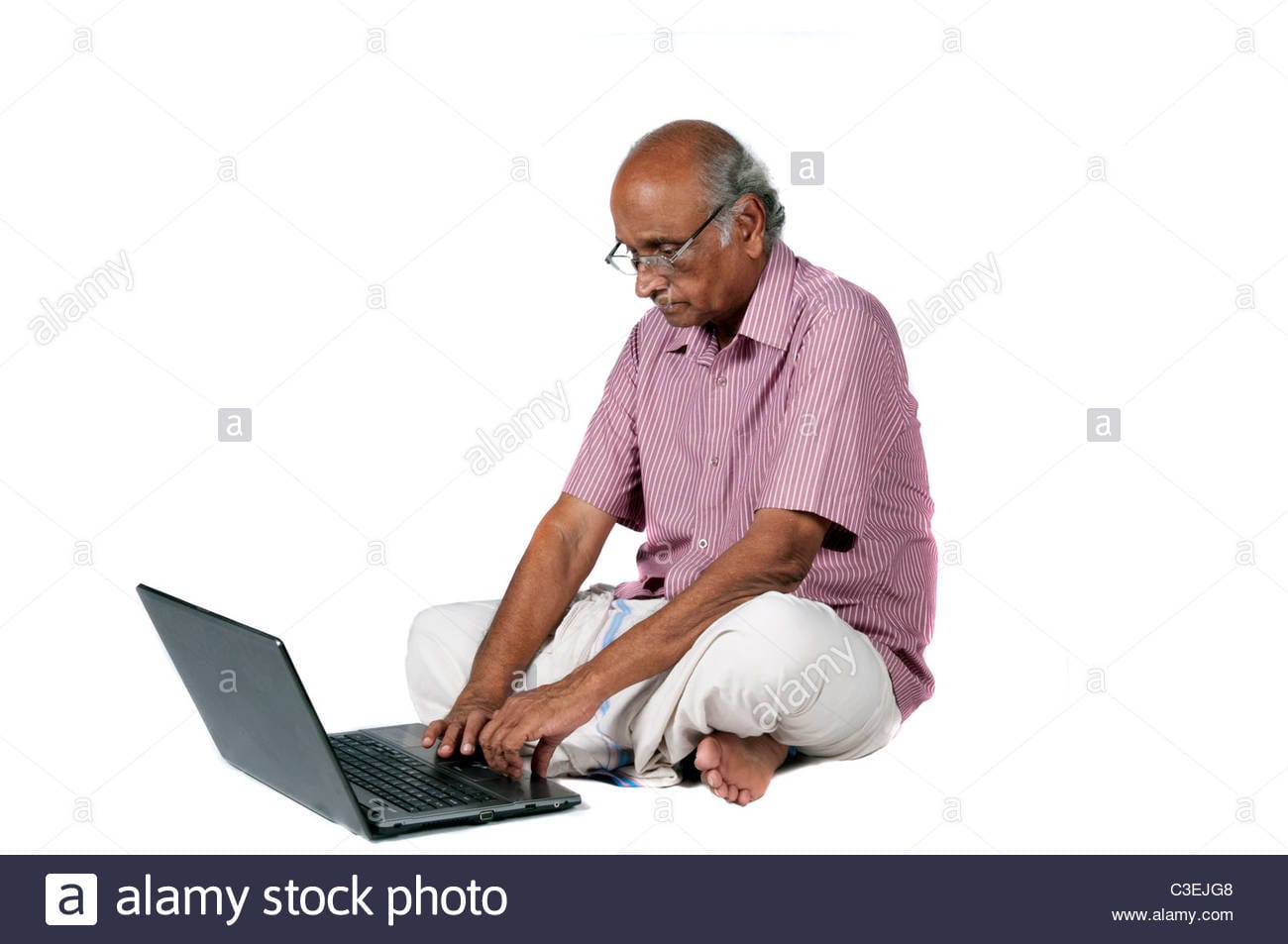 An old indian man surfing the net after retirement C3EJG8