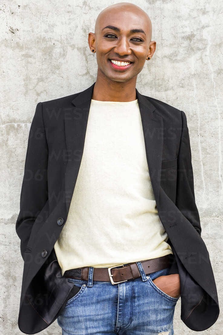 Smiling gay black man leaning on concrete wall BLEF04707
