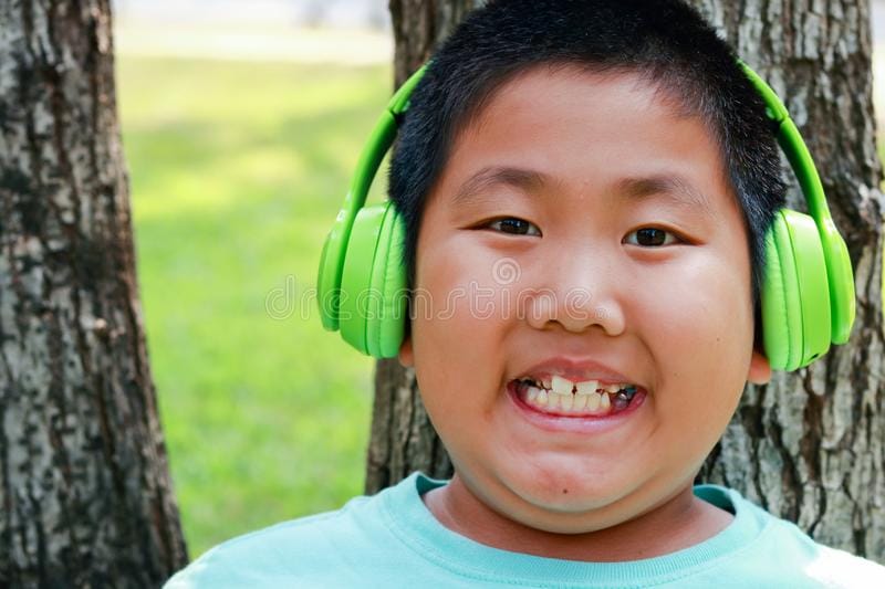 Fat asian boy wears green music headphones 162353223