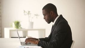 African american businessman working computer sitting suit office desk black man typing laptop