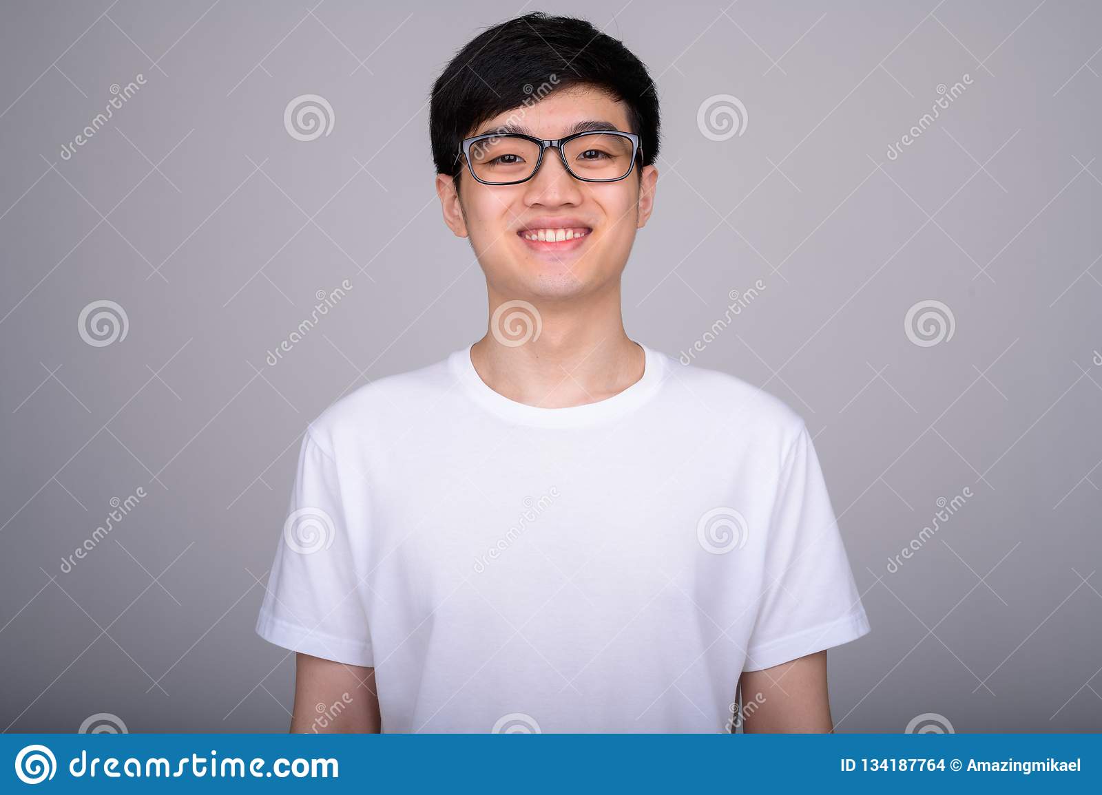Studio shot young happy asian nerd man smiling wearing eyeglasses against white background 134