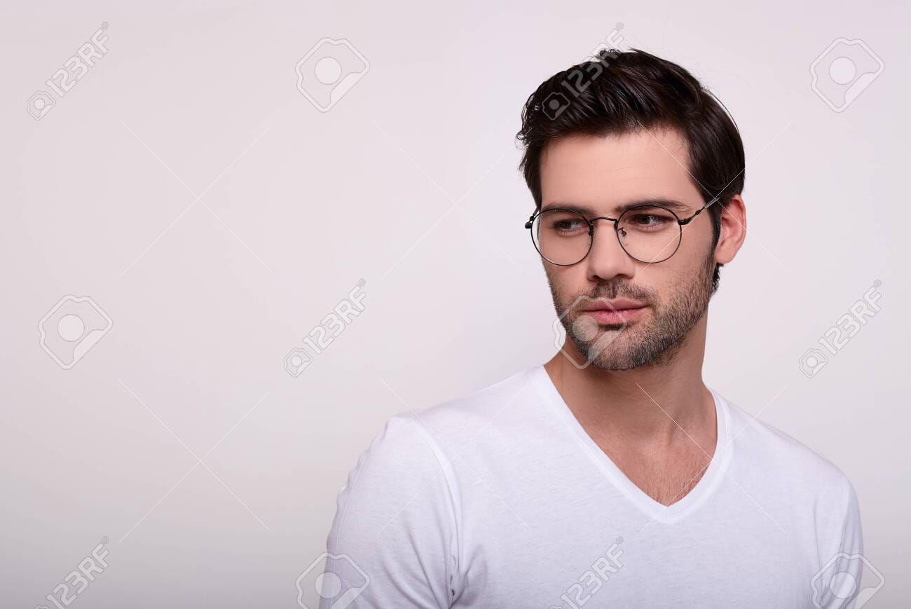 137828322 an elegant young white guy with dark hair and a beard in a white t shirt glasses fo