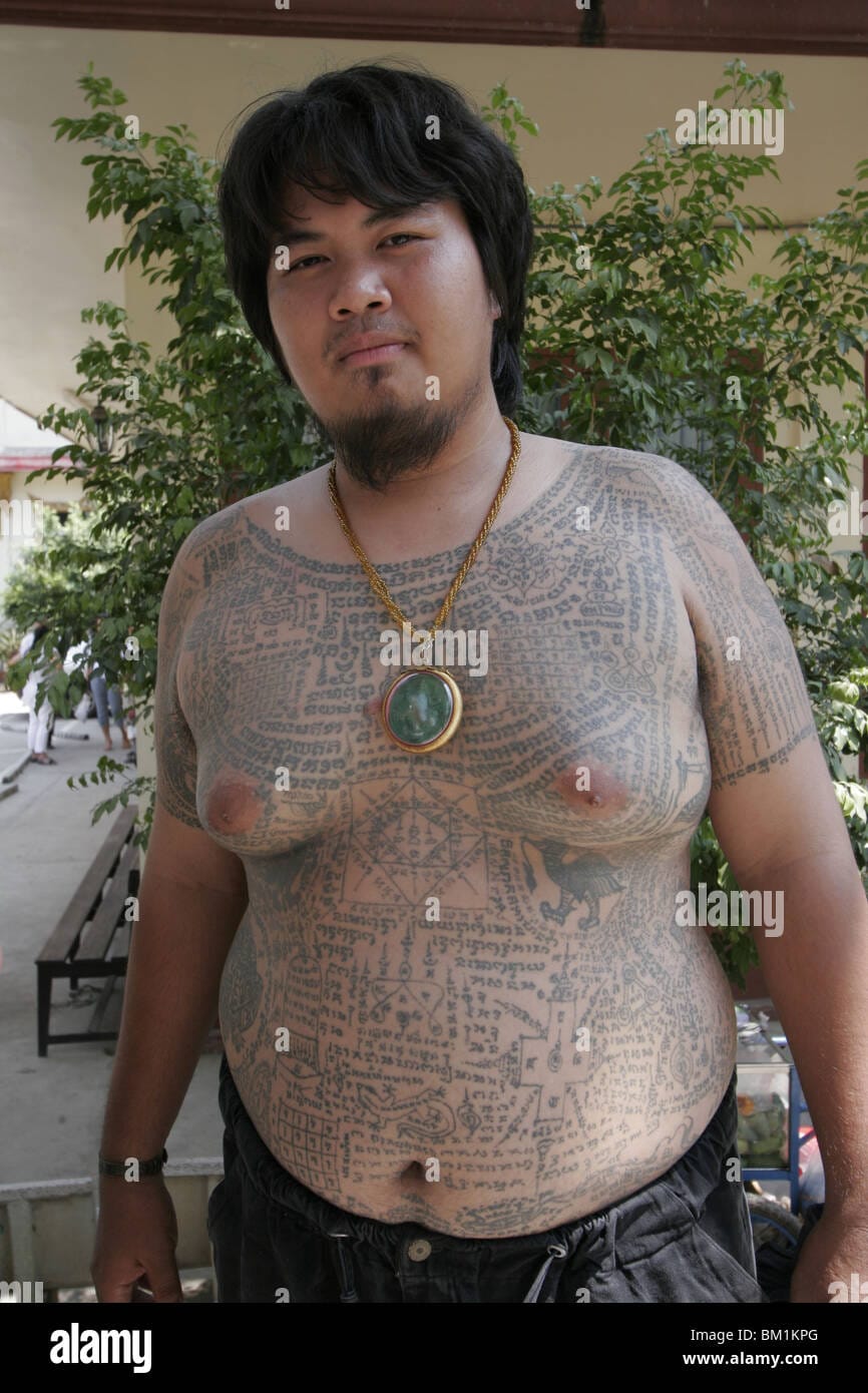 A fat young man shows off his tattoos during wai kru day at wat bang BM1KPG