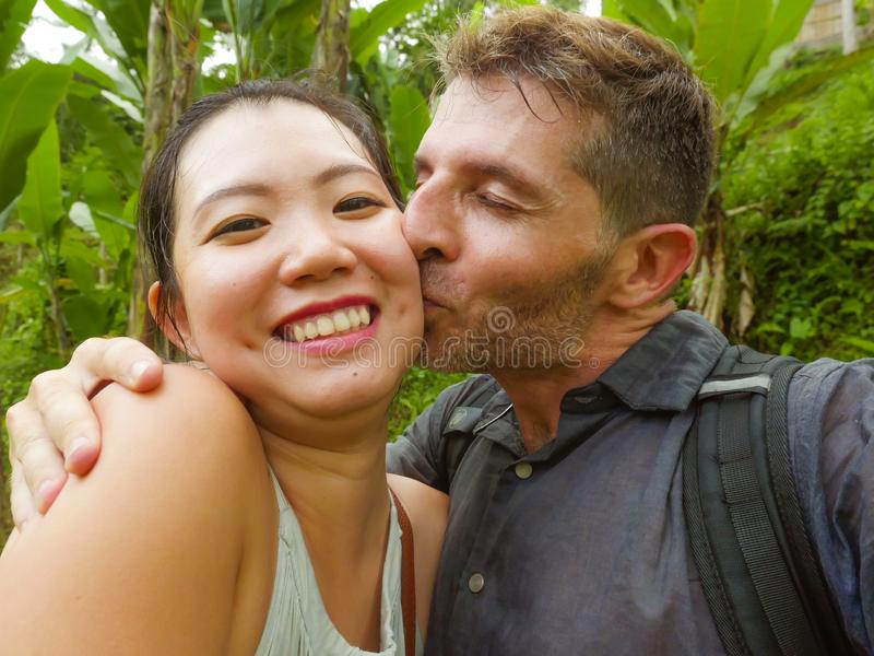 Young beautiful happy mixed ethnicity couple asian chinese women white men love taking selfie 