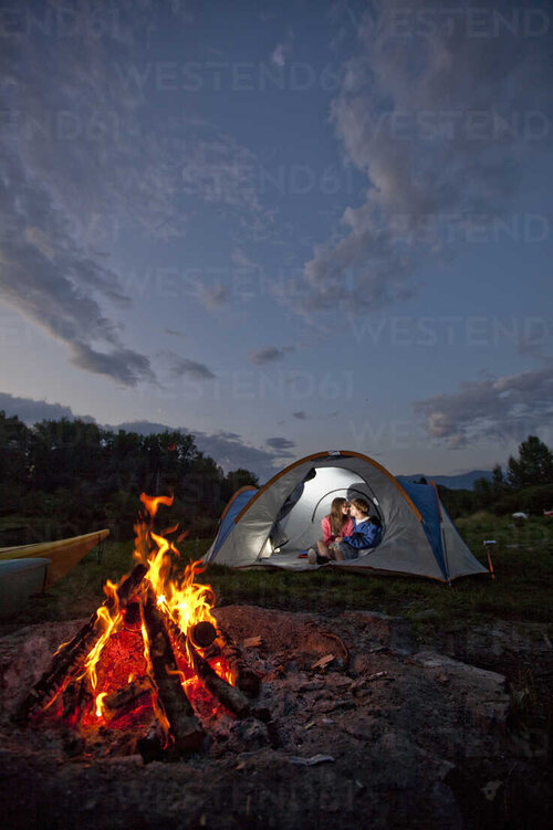 young-adult-couple-camping-with-a-camp-fire-and-kayaks-on-a-beautiful-summer-evening-AURF00106.jpg