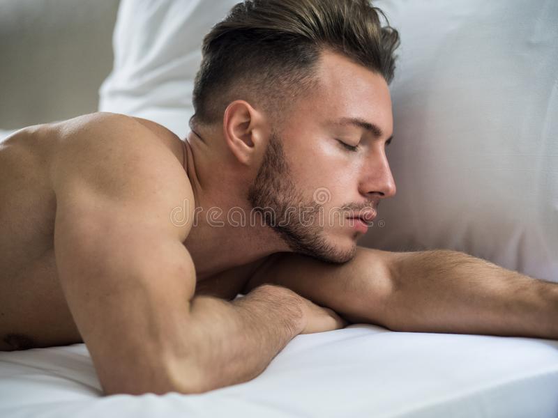 Handsome shirtless athletic young man laying bed night eyes closed sleeping 135314327
