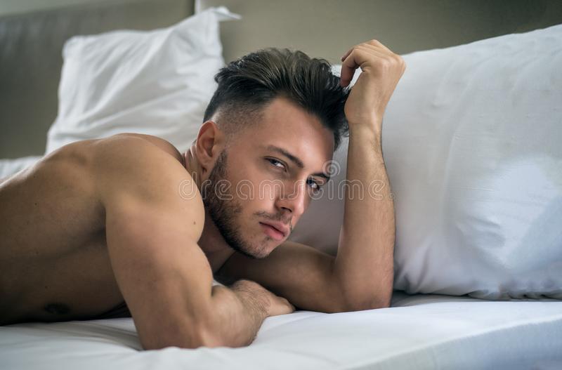 Shirtless sexy male model lying alone his bed shirtless sexy male model lying alone his bed hi