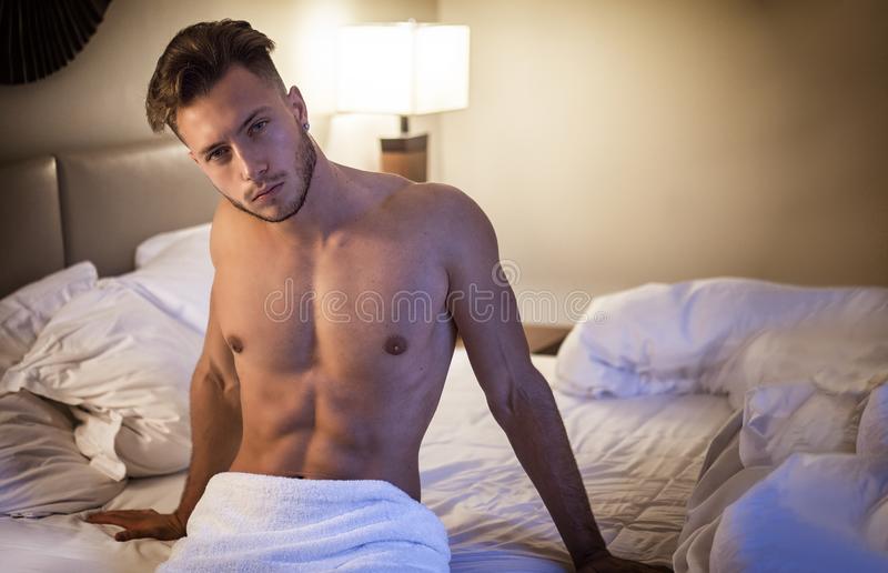 Shirtless male model lying alone his bed shirtless male model lying alone his bed his bedroom 