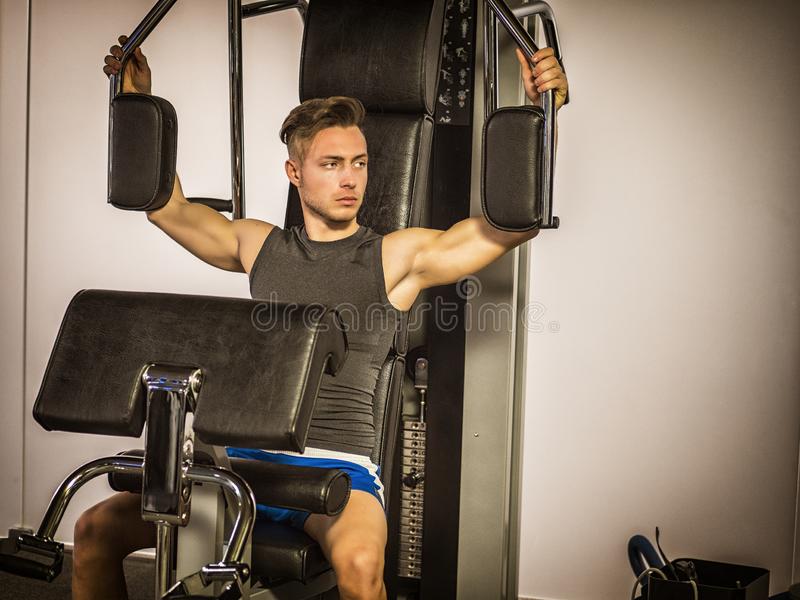 Muscular young man training pecs gym cable machine muscular young man training pecs gym machin