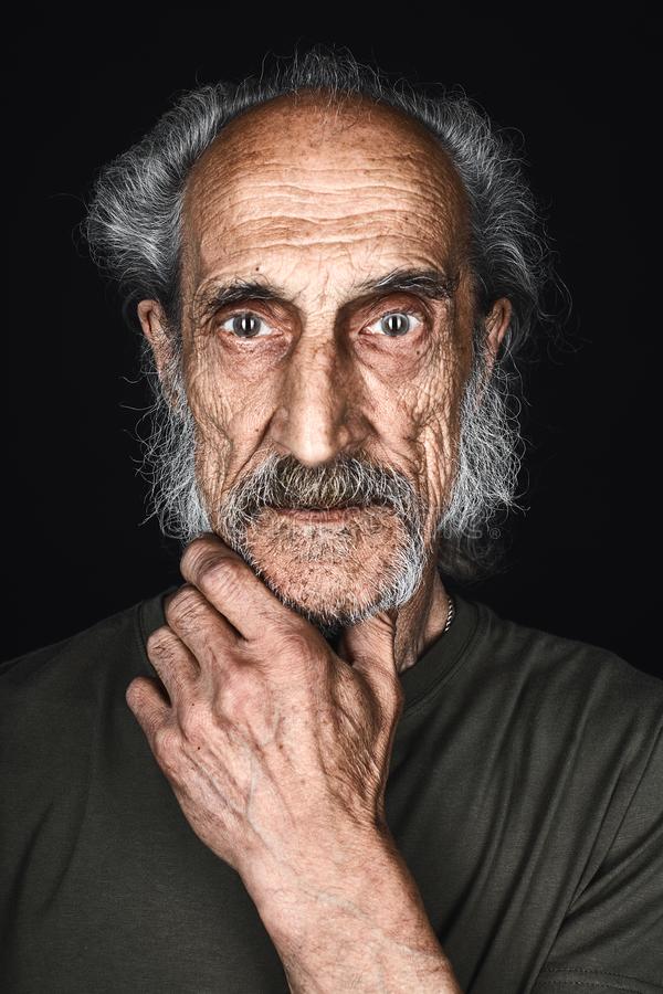 Old man plam chin loking camera scared expression thin mad skinny green t shirt palm looking c