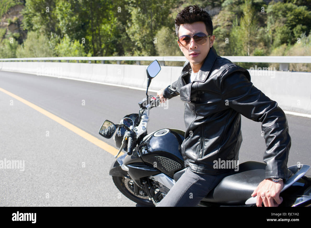 Young chinese man riding motorcycle FJC1H2