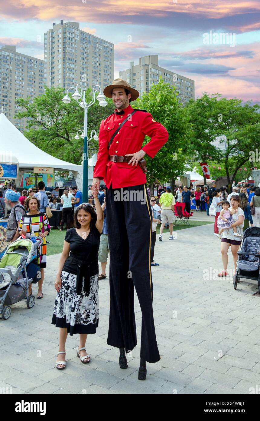 A man on stilts poses with the public during canadas day celebrations 2G4W8JT