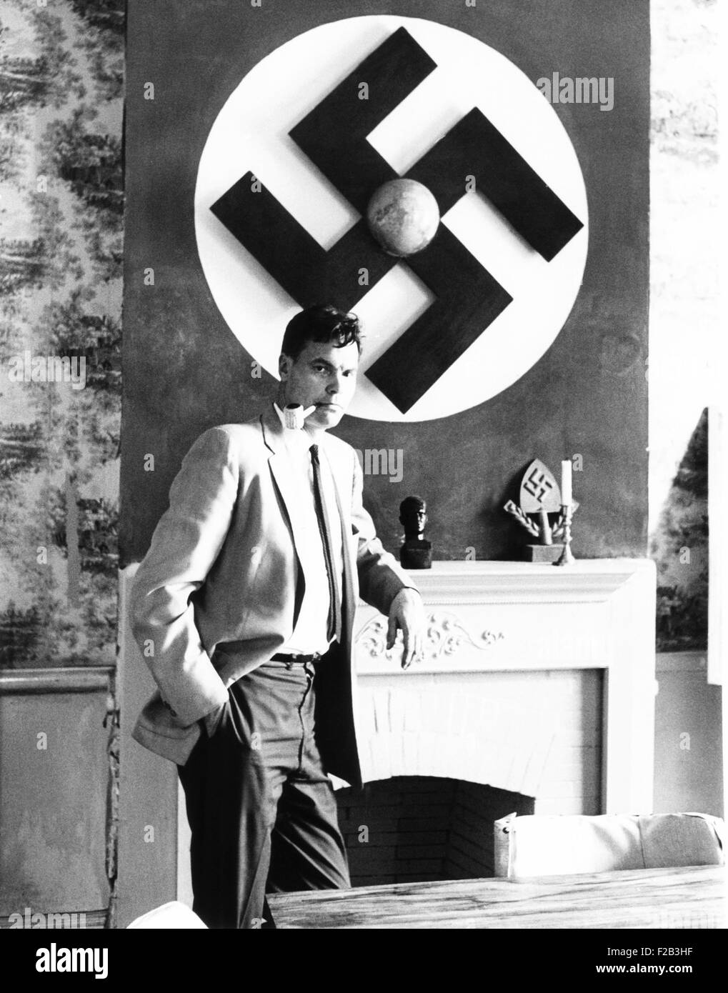 American nazi george lincoln rockwell steht ein riesiges hakenkreuz an der wand uber dem kamin
