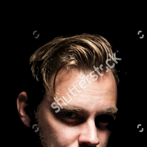 stock-photo-portrait-of-a-bearded-man-with-an-intense-look-standing-in-a-dark-room-against-a-b...jpg