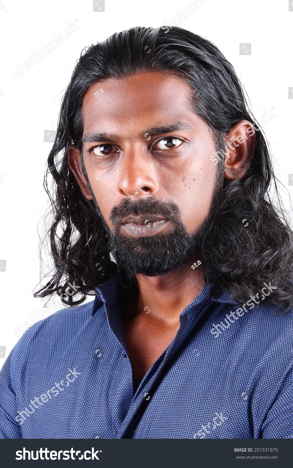 Stock photo young indian male with long hair posing the camera with a serious look 207331879