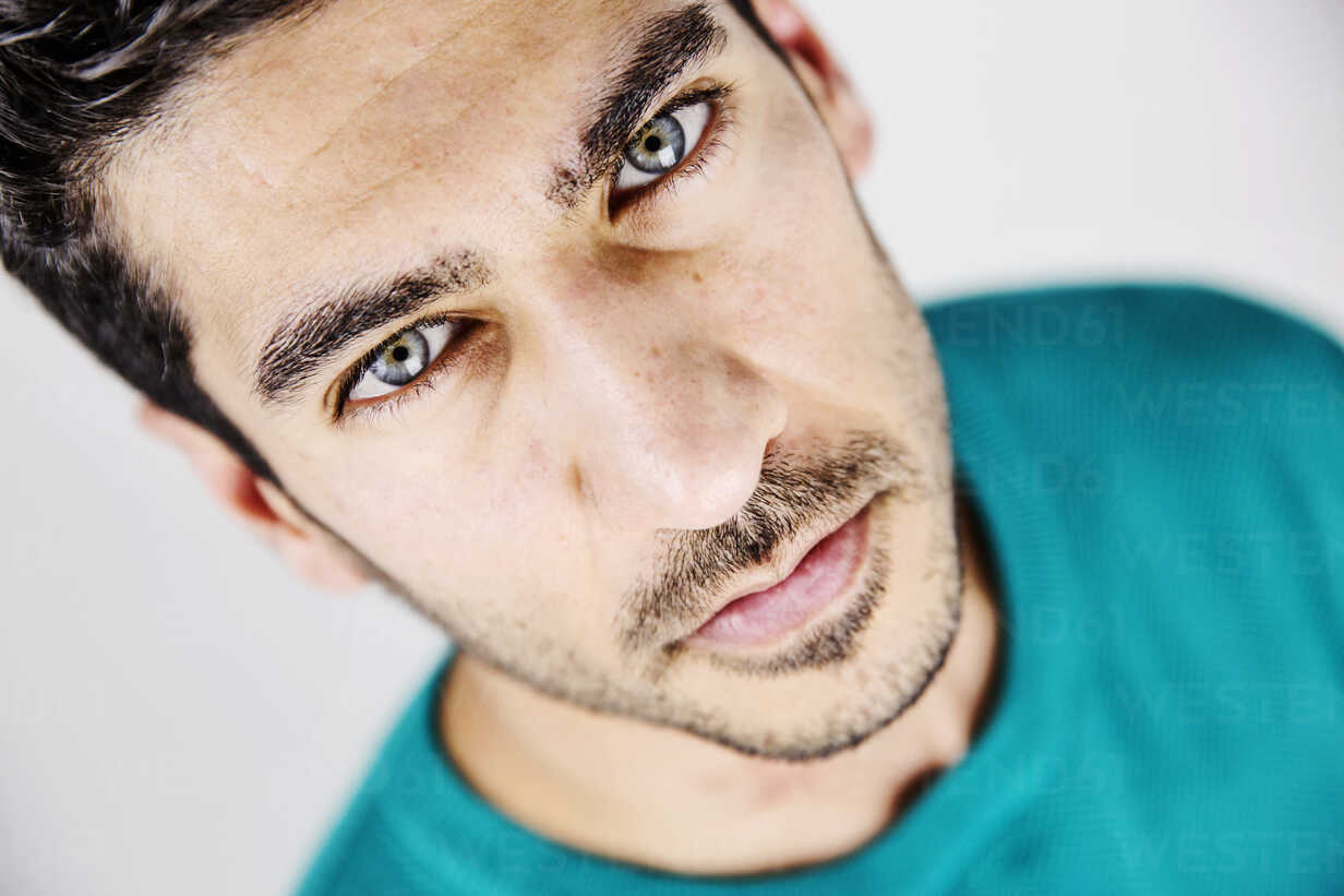 Portrait of serious young man with blue eyes and stubble JATF01037