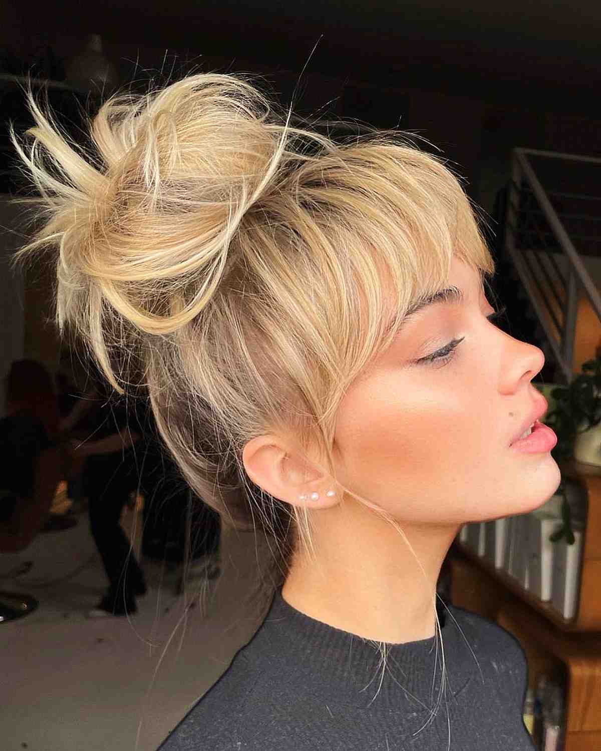 Messy top knot updo with bangs