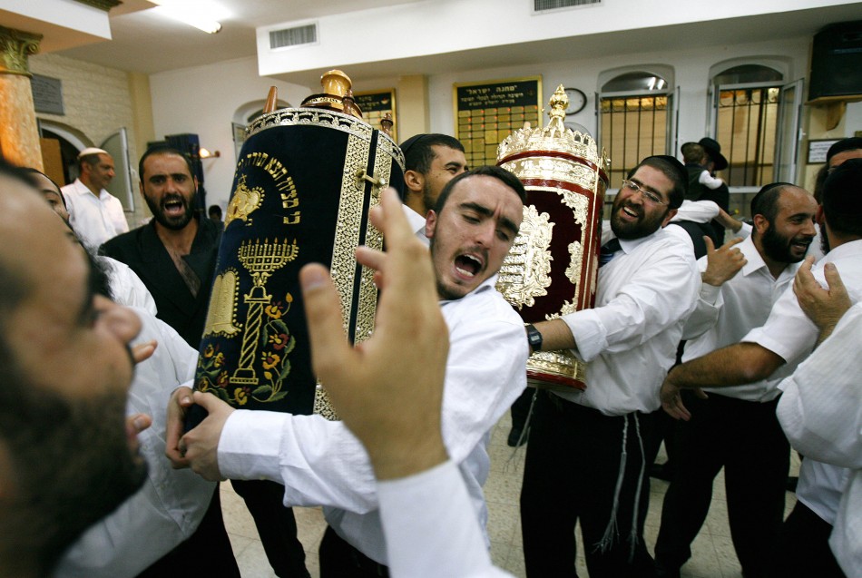 Ultra orthodox jews dance scroll torah during jewish holiday simchat torah synagogue mea