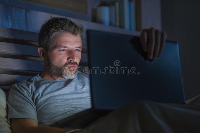 Man alone bed playing cybersex using laptop computer watching porn sex movie late night lasciv