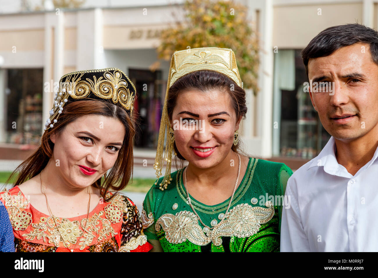 Three young uzbek people women in traditional costume pose for a photo M0RRJ7
