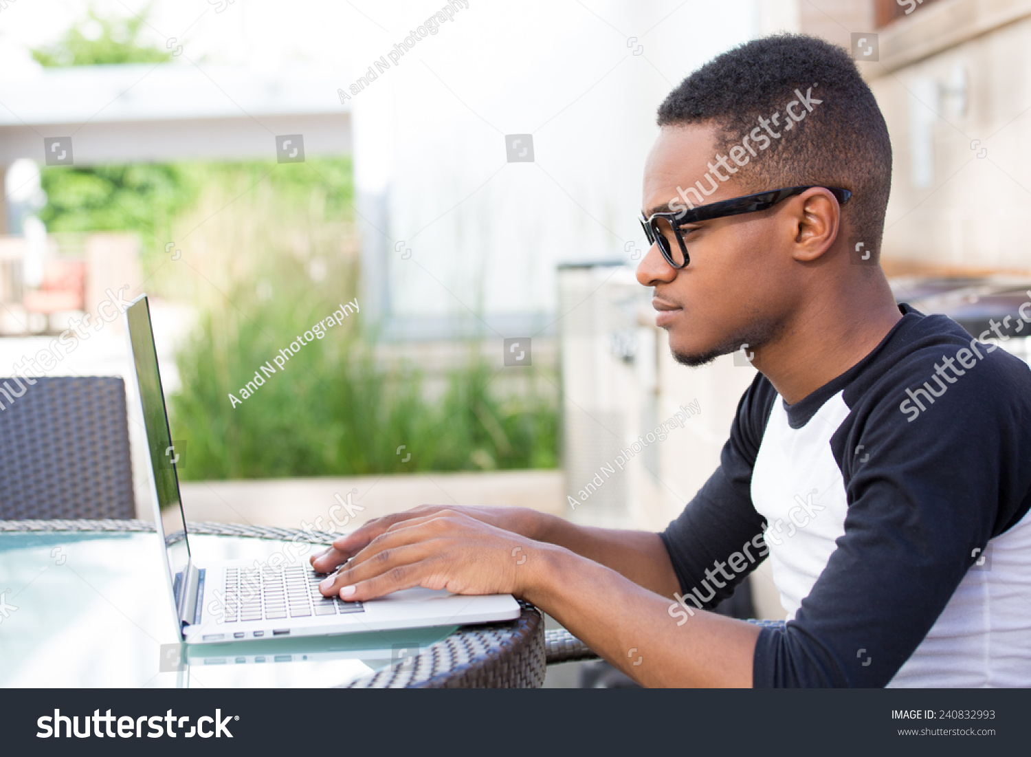 Stock photo closeup portrait young nerdy man in big black glasses surfing the web on personal 