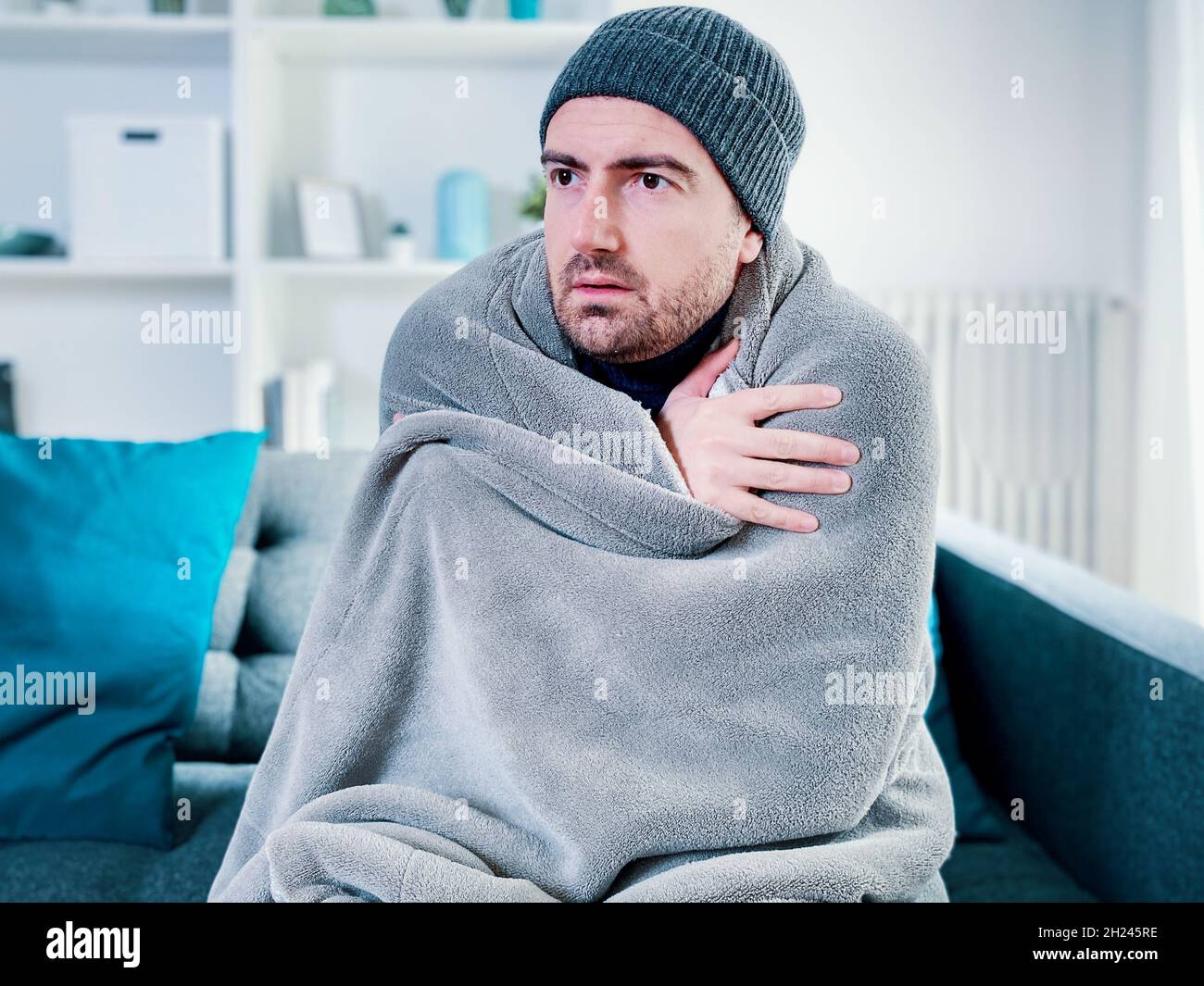 Man feeling cold at home with home heating trouble 2H245RE