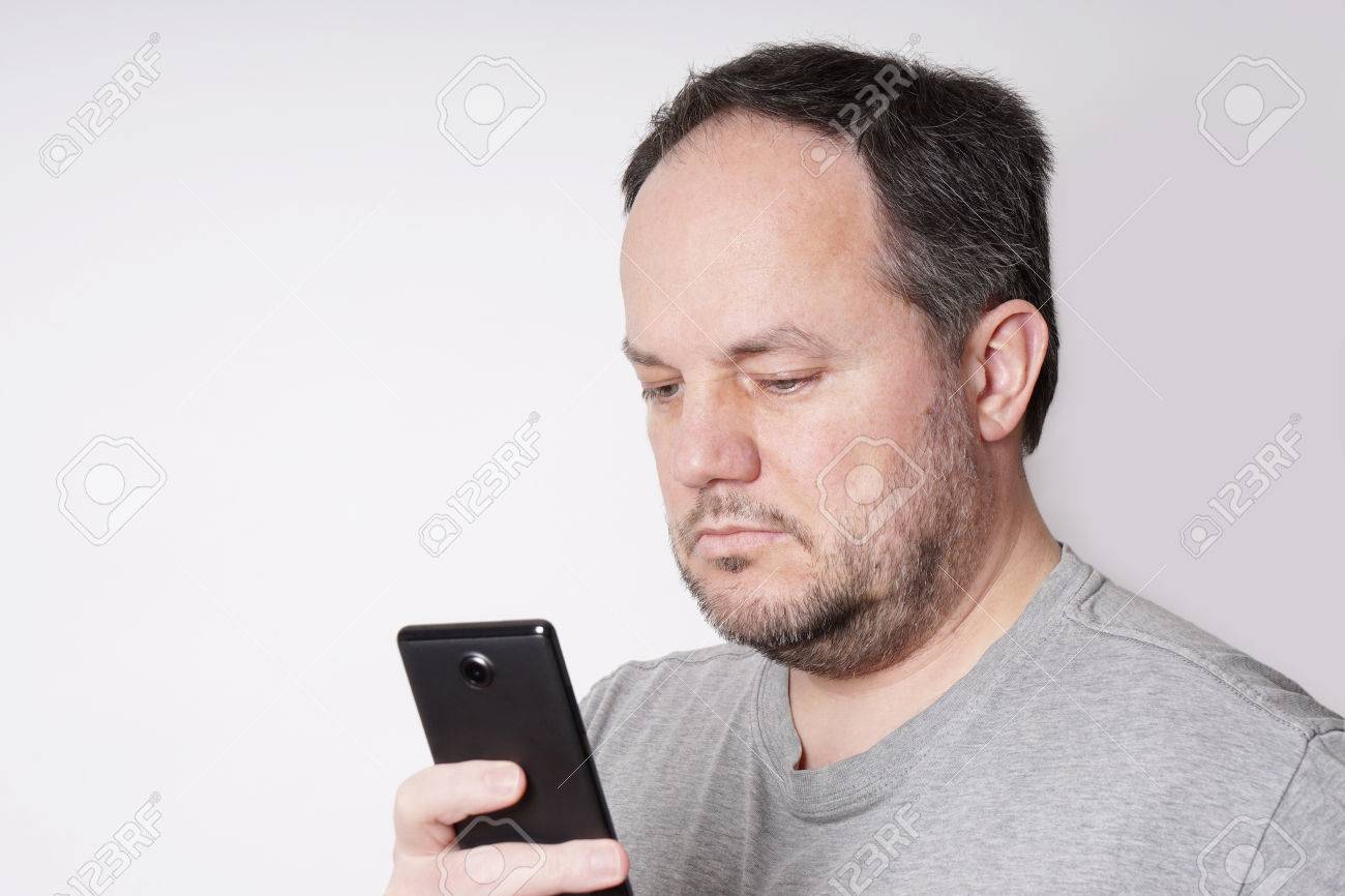 38914066 middle aged man looking down at his mobile smart phone