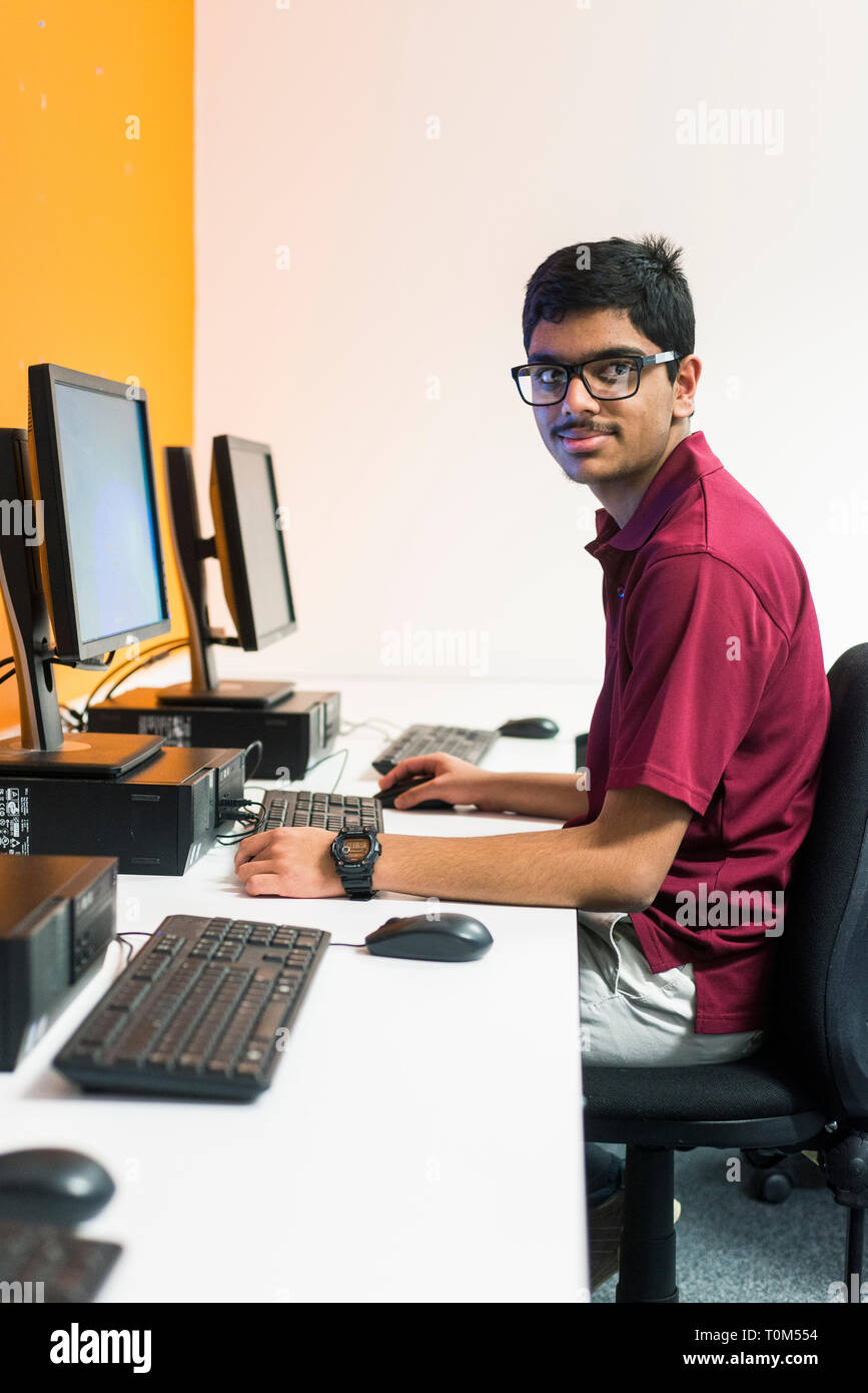 A young international student from the indian subcontinent works in the computer room of a mod