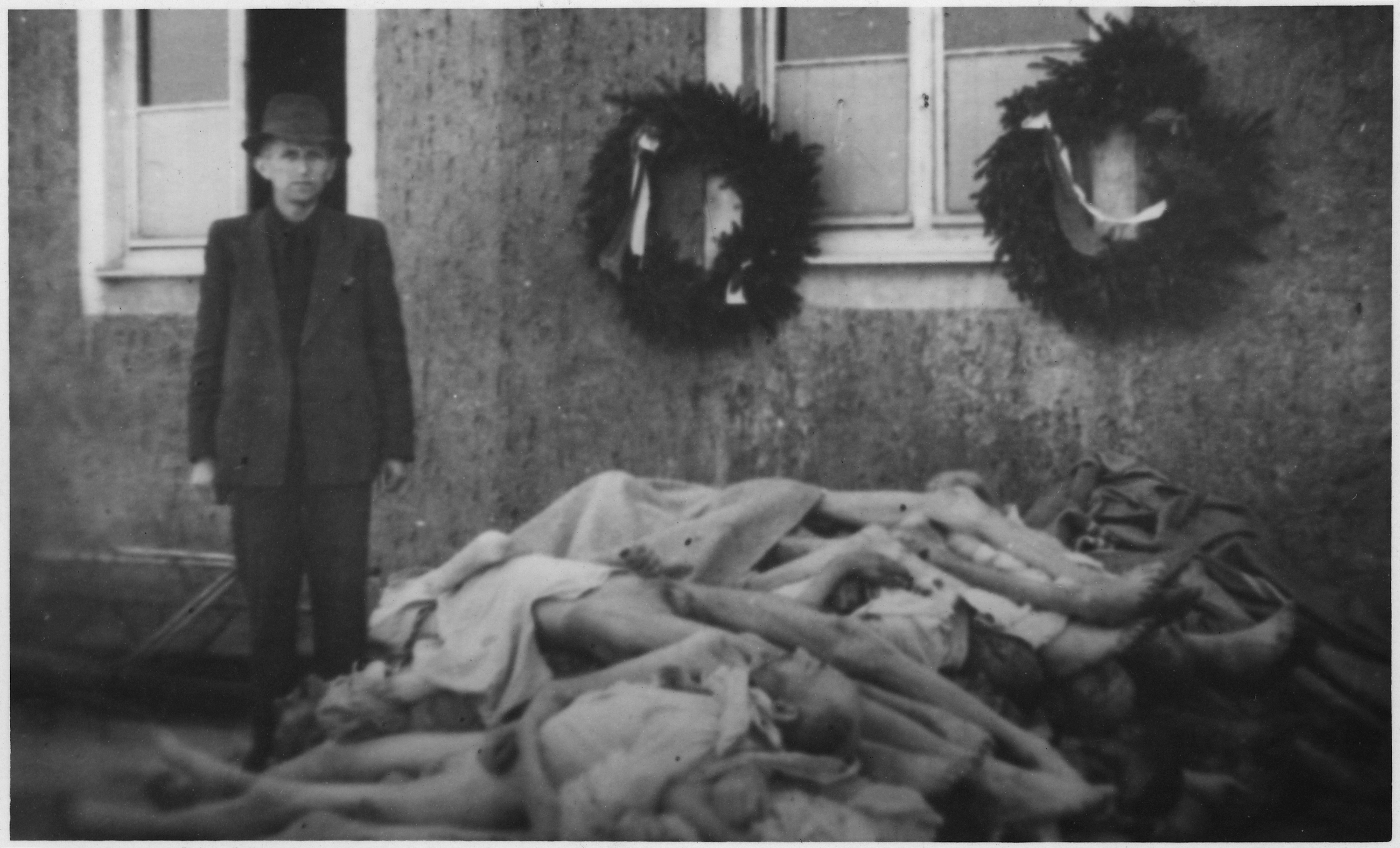 WWII Europe Buchenwald Germany Concentration Camps  Man stands next to pile of dead bodies