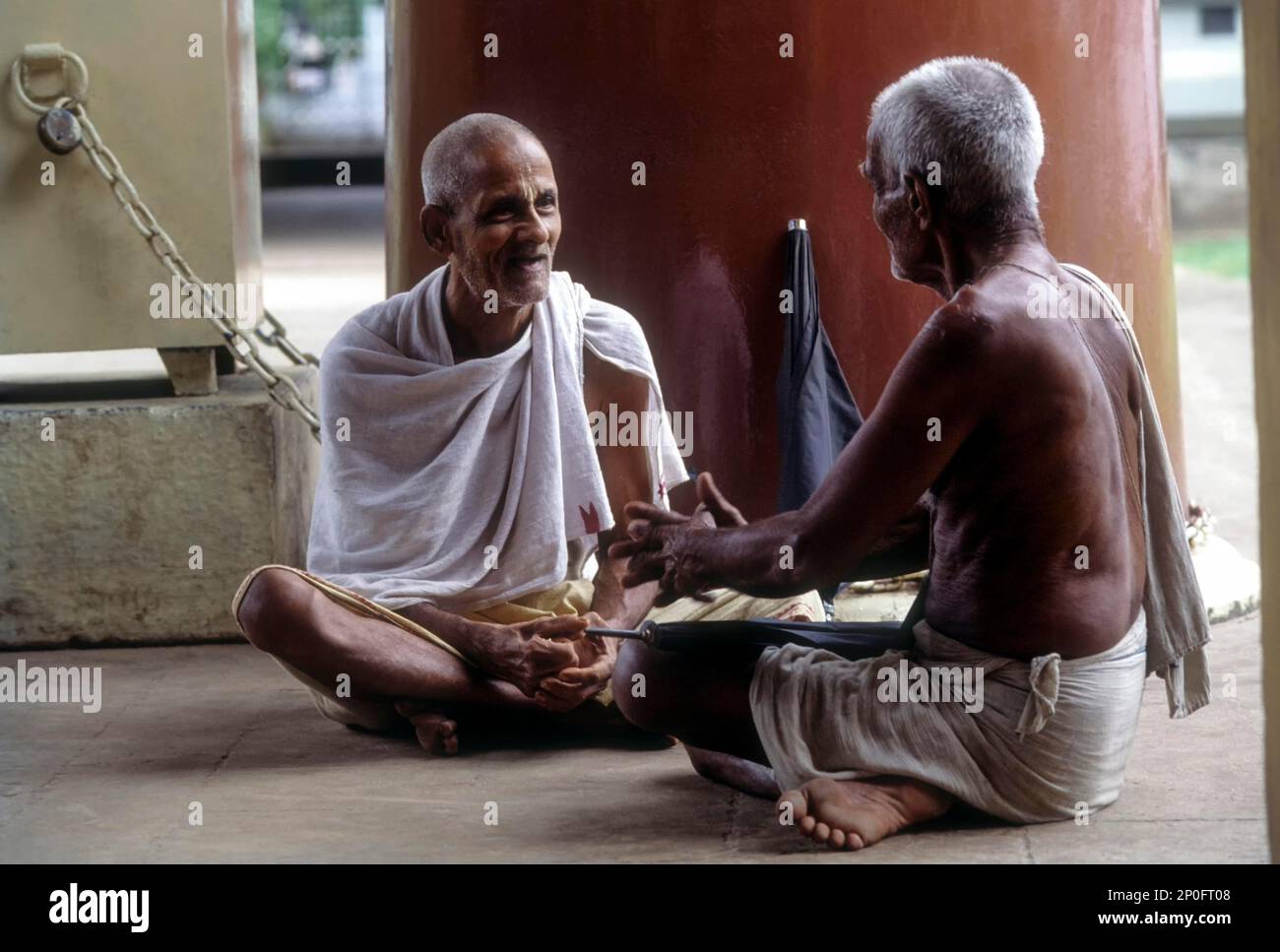 Two old man joyfully chit chatting in the temple kochi cochin kerala india 2P0FT08