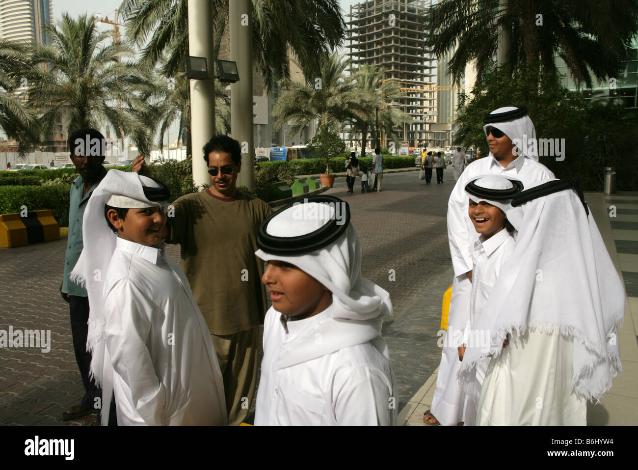 Qatari boys in traditional attire on the street of doha qatar B6HYW4