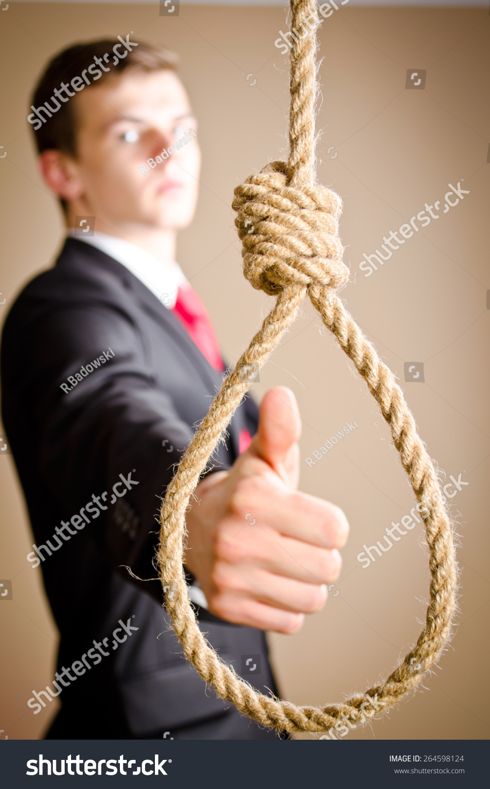 Stock photo man in suit giving thumbs up with hanging noose 264598124