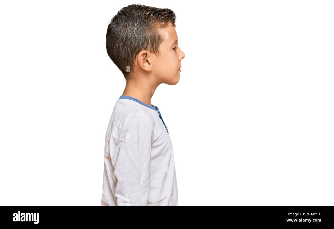 Adorable caucasian kid wearing casual clothes looking to side relax profile pose with natural 