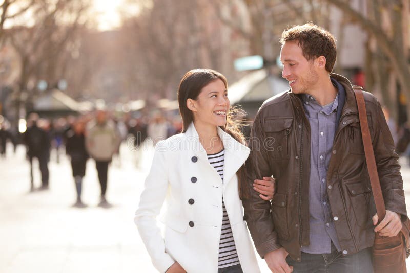 Urban couple walking la rambla barcelona arm arm romantic laughing lovers talking holding hand